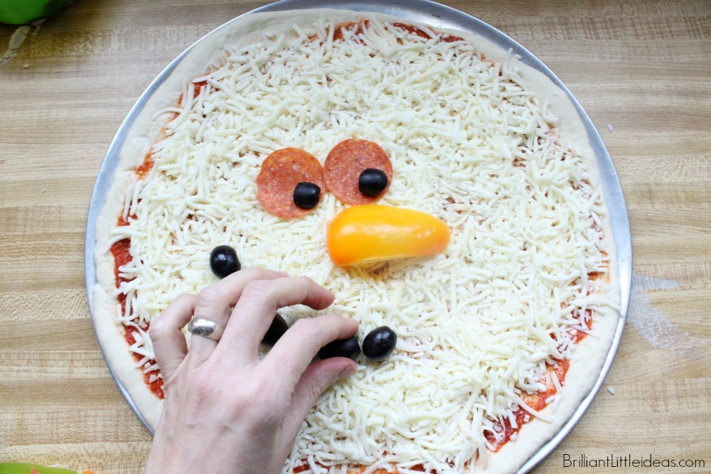 Have a memorable Christmas movie night with popcorn and this Fun Snowman Pizza Recipe for Kids. #Christmas #holidays #snowman #kidfun #homemadepizza 