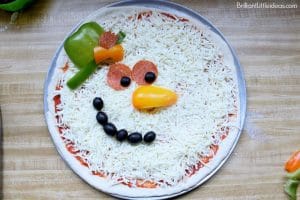 Have a memorable Christmas movie night with popcorn and this Fun Snowman Pizza Recipe for Kids. #Christmas #holidays #snowman #kidfun #homemadepizza