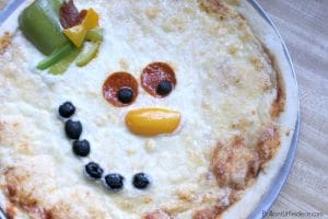 Have a memorable Christmas movie night with popcorn and this Fun Snowman Pizza Recipe for Kids. #Christmas #holidays #snowman #kidfun #homemadepizza