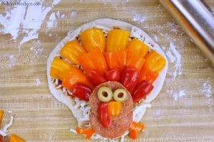 Sick of Thanksgiving food but still want something festive? Try this DIY Turkey Pizza for your kids. #Thanksgiving #kidfood #holidayfun #pizza #homemadeizza